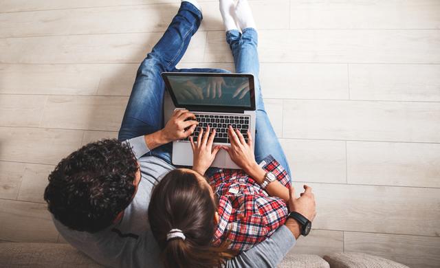 Overhead view of couple using computer on couch